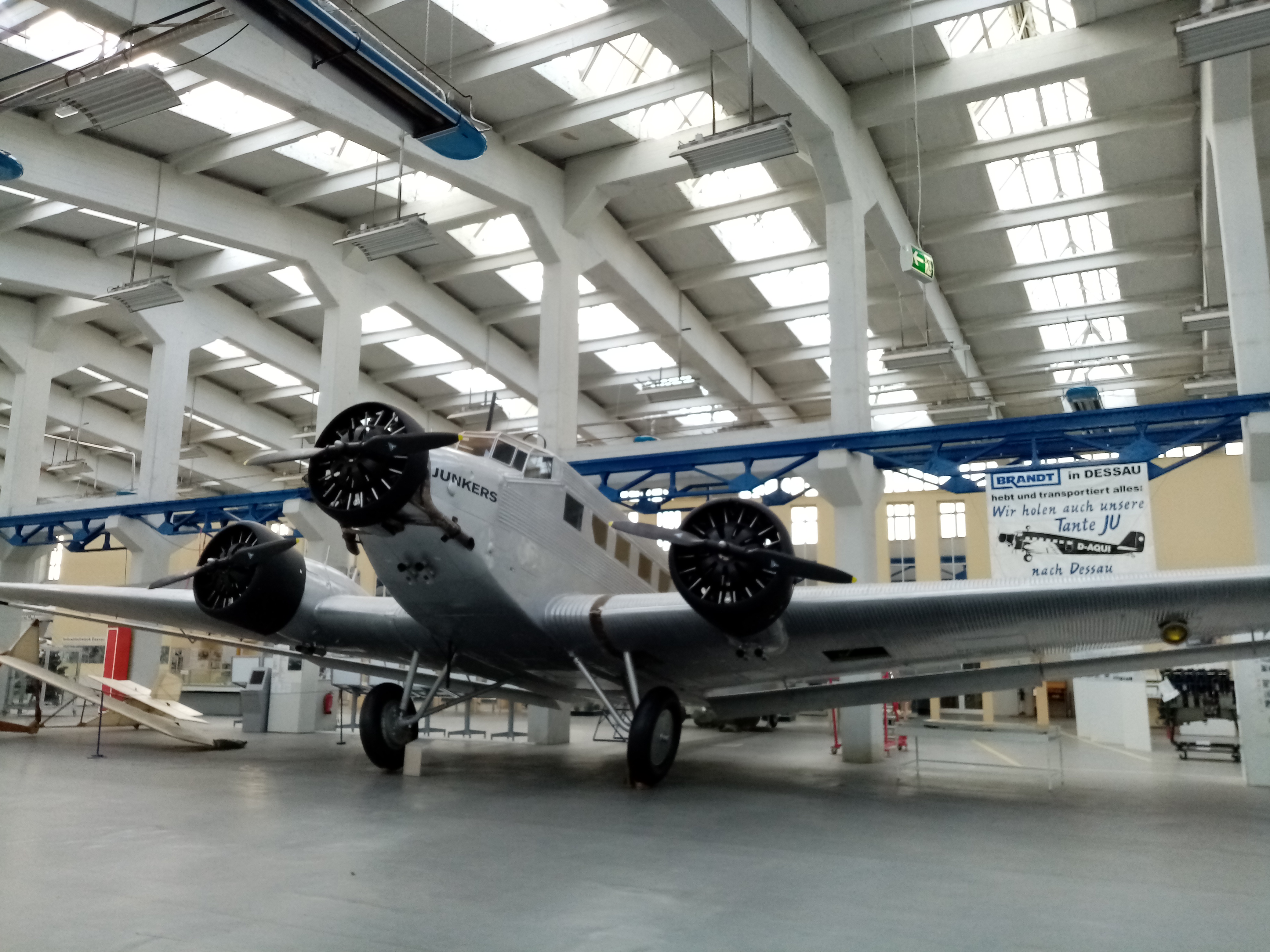 Ein Flugzeug mit der Aufschrift "Junkers" steht in einer großen Halle